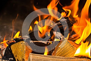 Folded bonfire firewood part of a solid log bright orange bright flame closeup background base home cosiness