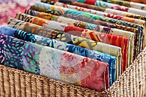 Folded bright pieces of quilting batik fabrics in a basket, macr