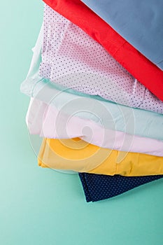 Folded colorful pants and jeans. Stack of bright female trousers. Close up.
