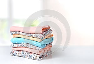 Folded cotton clothes stack on table empty background