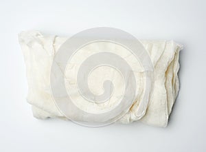 Folded cotton white gauze fabric on a white background