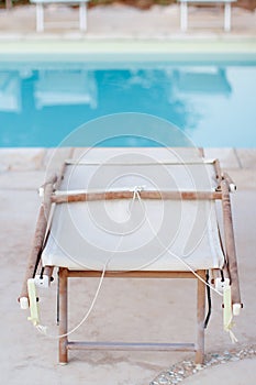 Folded deck chairs near a swimming pool in a garden