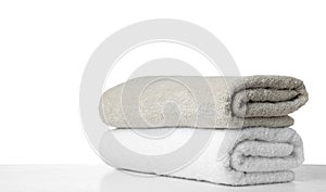 Folded fresh clean towels for bathroom on table against background. Space for text