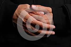 Folded hands of a priest