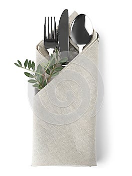 Folded napkin with fork, spoon and knife on white background