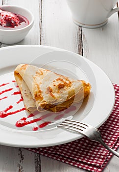 Folded pancake on white plate