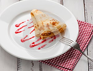 Folded pancake on white plate