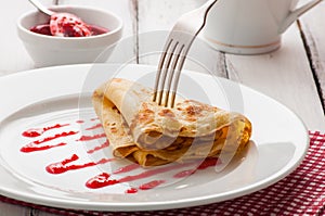 Folded pancake on white plate