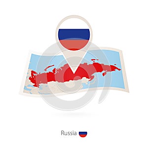 Folded paper map of Russia with flag pin of Russia