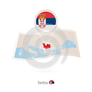 Folded paper map of Serbia with flag pin of Serbia