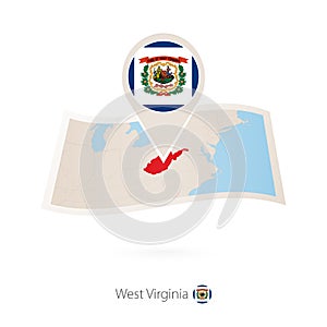 Folded paper map of West Virginia U.S. State with flag pin of West Virginia