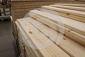 Folded planed boards on the background of other goods wholesale warehouse.