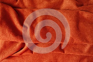 Folded reddish orange artificial suede fabric