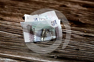 Folded Saudi Arabia money of 5 SAR five riyals isolated on wooden background, wrinkled 5 Saudi Riyals cash bill banknote,