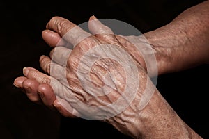 Folded senior woman wrinkled hands close up. Old age, age problems, poverty and loneliness theme