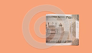 Folded set of Indian 500 Rupee currency bills isolated on Apricot background