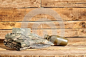 Folded soldier uniform and bottle.