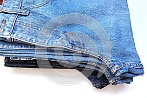 Folded stack jeans multicolor islolated on white background closeup.