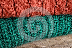 Folded warm sweaters on wooden table