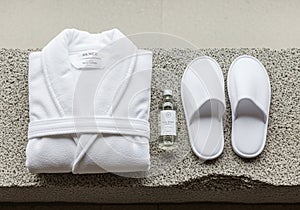 White bathrobe, labeled with RENCE , rests on a textured concrete