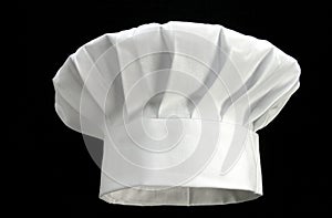 Folded white chef`s hat on a black background
