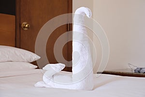 Folded from a white towel swan on the bed in the hotel room