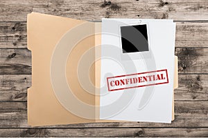 Folder with confidential papers on wooden table