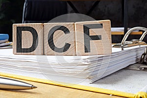 Folder and cubes with letters DCF Discounted Cash Flow.
