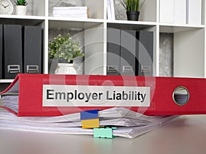 The folder Employer liability lies on a stack of papers.