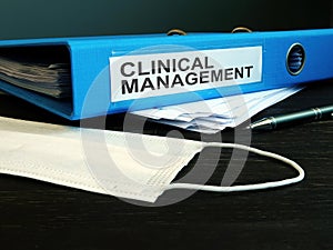 Folder with label clinical management and medical mask