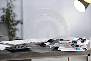 Folders with documents and calculator on office table.