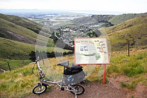 Folding bicycle near walking trail information plate