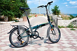 A folding bike stands on the Black Sea embankment