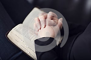 Folding Hands over a Bible