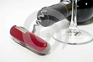 Folding knife with wine opener, glass and wine bottle on a white background