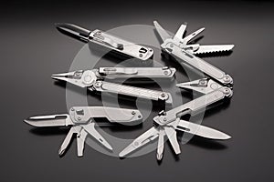 Folding multitools and knives on a dark background. Metal pocket multi-tools