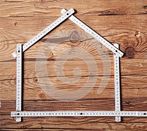 Folding Ruler Forming a House on Wooden Table