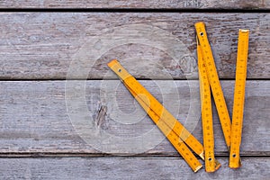 Folding ruler on old wooden background.