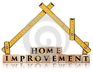 Folding ruler in the shape of house and wooden text Home Improvement