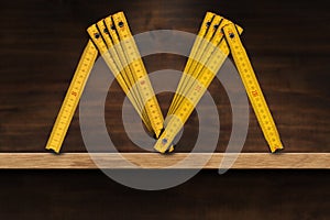 Folding Ruler in the Shape of Letter M on a Wooden Shelf