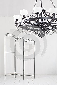 Folding screen and a black chandelier in a room