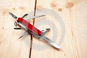 Folding swiss knife, a knife with a variety of devices on a wooden