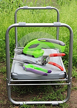 Folding table- chair on which garden tools for pruning plants and trees