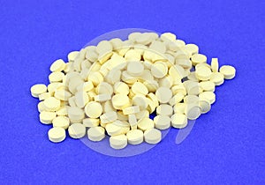 Folic acid pills on blue background