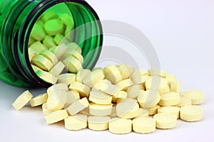 Folic acid spilling from green pill bottle