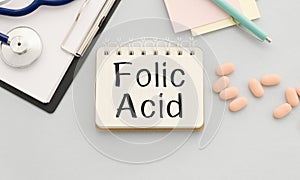 FOLIC ACID is written in a notebook on a blue