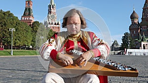 Folk performer with music instrument gusli