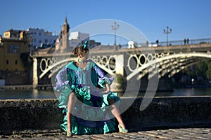 The sexi flamenco girl, sitting at the edge of the Guadalquivir river near the bridge of Isabella la Cattolica, also called Triana photo