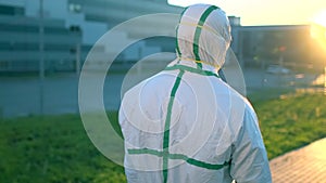 Follow of doctor virologist scientist in PPE personal protective equipment suit walking near hospital clinic