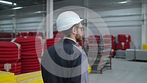 Follow footage of employees male warehouse worker engineer in hard hat working
